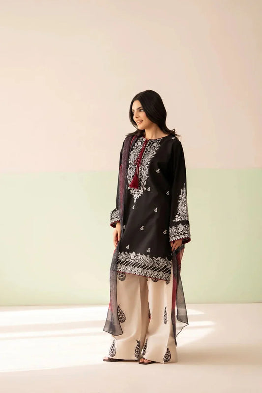 Shai Noor Gul e Siyah 3-piece embroidered lawn suit for women, featuring intricate black embroidery on fabric with matching dupatta and trousers.